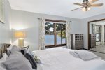 Main level primary bedroom with a king size bed and waterfront views of Hutchins Lake
